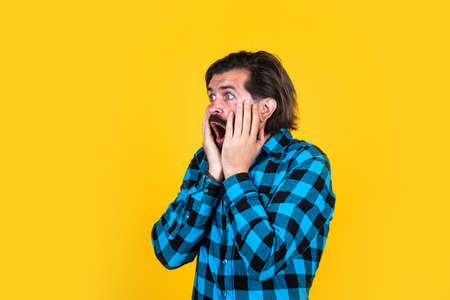 bad news. scared about something. bearded man in checkered shirt. brutal guy with emotional face. casual male fashion look. surprised handsome hipster. barbershop. mature man has moustacheの写真素材