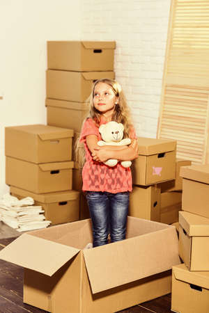 Service with a Lifestyle. happy child cardboard box. happy little girl with toy. purchase of new habitation. Moving concept. new apartment. Cardboard boxes - moving to new houseの写真素材