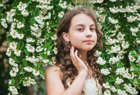Beautiful girl long curly hair spring flowers background, inspired by nature concept