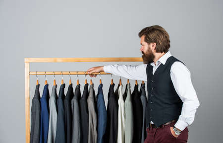 Man picking suit from personal wardrobe, tailored blazer conceptの写真素材