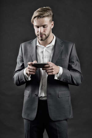 Manager with beard on serious face hold phone.の写真素材