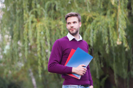 college student guy study with notebook outdoor preparing for exam and graduation, educationの写真素材