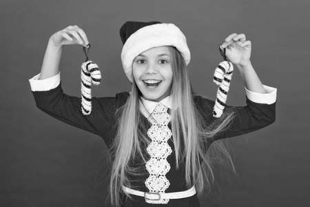Add more decorations. Christmas decorating ideas. Child Santa Claus costume hold christmas candy cane. Create unique decorations. Christmas decor. Striped candy cane traditional for winter holidaysの写真素材
