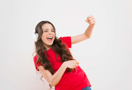 Top songs. Child teen enjoy music playing in earphones. Little girl enjoying favorite music. Catch the rhythm. Kid listening music headphones. Entertainment and fun. Whole musical world in her earsの写真素材