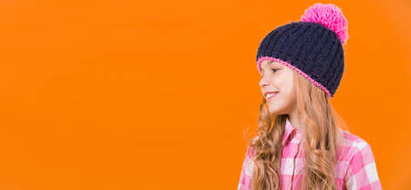 Girl child with long, blond hair smile on orange backgroundの写真素材