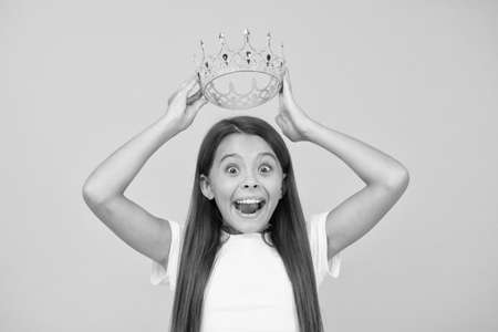 what a surprise. little beauty queen. the greatest reward. happy childhood. good motivation for child. kid glamour fashion. live in luxury. kid dream is being princess. small girl wear golden crownの写真素材