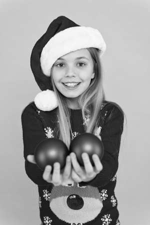 Festive mood. Add more decorations. Getting child involved decorating. Decorative accessories. Decorating christmas tree. Girl smiling face hold balls blue background. Let kid decorate christmas treeの写真素材