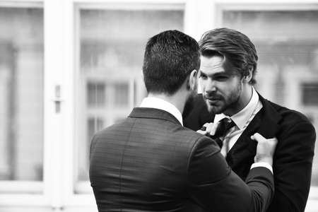 Conflict. Businessmens fight in elegant suits at officeの写真素材