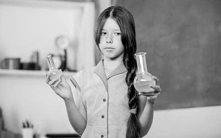 Biology education. Girl chemistry class testing tube. Scientific experiment. Fascinating lesson. Chemical reaction. Chemical liquid. Science lesson. School laboratory. Small girl with chemical tubeの写真素材