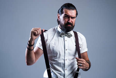 mature bearded man hipster with moustache wear suspenders and bow tie, vintage fashion lookの写真素材