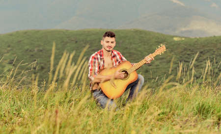 Cause the streets are singing. country music song. sexy man with guitar in checkered shirt. hipster...