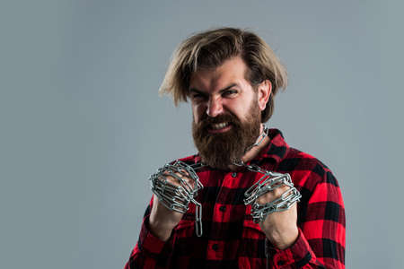 man has heavy steel chain on neck. conceptual symbol of freedom. male fashion. strong man with...