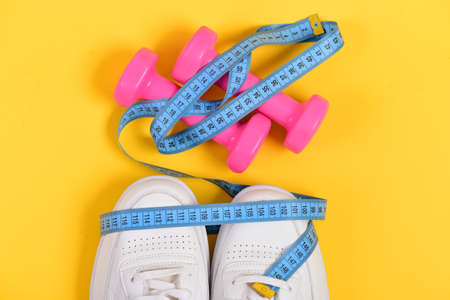 Fitness and sportswear concept. Sneakers with measuring tapeの写真素材