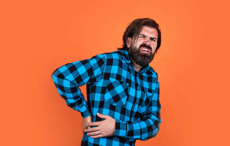 bearded man suffering from backache has pain in back and health problems, rheumatismの写真素材