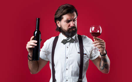 you should try this. brutal guy bartender in bow tie. elegant male barman. handsome hipster drinking wine glass. sommelier tasting alcohol. bearded man in suspenders drink red wineの写真素材