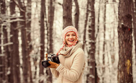 Happy tourist woman in winter. professional photographer outdoor in winter. woman use vintage...