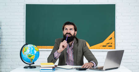 man thinking and writing in notebook while passing school exam, education