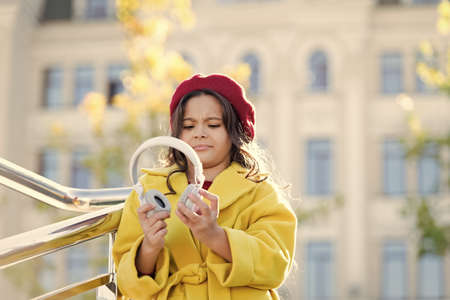 Little girl listening music enjoy favorite song excellent sound. Good vibes only. Awesome sound. Girl kid with headphones urban background. Stereo sound. Child girl autumn outfit enjoying musicの写真素材