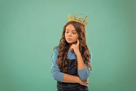 Thoughtful baby. Lady little princess. Girl wear crown. Princess manners. Winner of beauty competition. International beauty contest. Kid wear golden crown symbol of princess. Become princessの写真素材