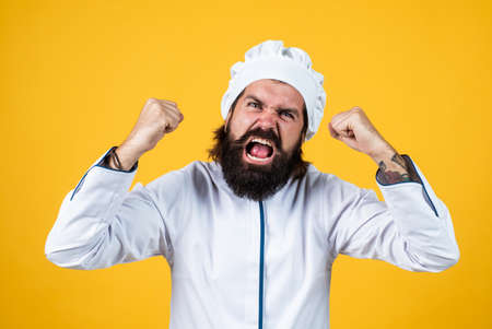 unfriendly look. angry man shouting. concept of housekeeping. mature bearded man wear chef hat. male cook ready for preparing food. brutal hipster in apron going to be cooking meal. time for eatingの写真素材