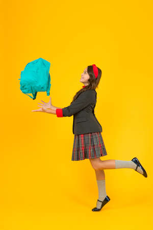 Stay organized this school year. Happy kid throw bag up yellow background. Schoolbag. School bag....