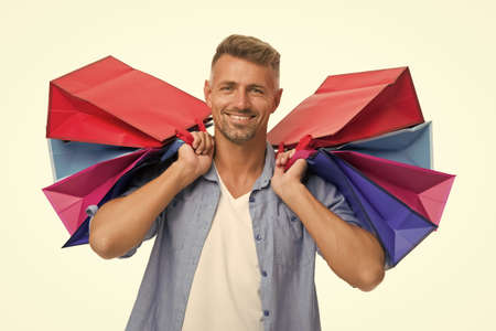 avid shopaholic. happy man with packages after shopping. handsome man care heavy shopping bags. buy...