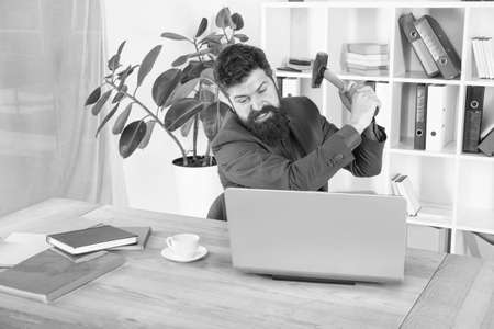 hate my job. dealing with error. overworked man crush laptop with hammer. frustrated computer user. businessman express anger. ready to smash. Office life makes him crazy. Slow internet connectionの写真素材
