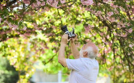 Images that tell story. Power behind picture. Vintage camera. Retro camera. Senior man holding...