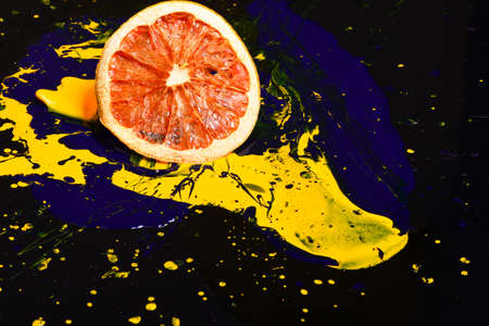 Orange or grapefruit half covered with paints.の写真素材