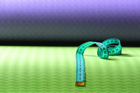 Flexible ruler in blue lying on yoga mat, copy space.