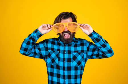 try on a new style. funny and joyful man wear checkered shirt. just having fun. happy brutal party goer. mature bearded hipster in good mood. fashion concept. trendy man in funny party glassesの写真素材