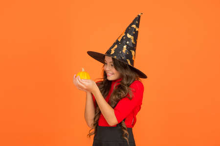 halloween child in witch hat costume with pumpkin, halloween party