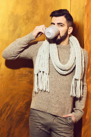 bearded man drinking tea, coffee from cup with serious faceの写真素材