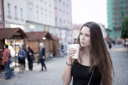 Woman with takeaway drink walk on street. Woman hold disposable coffee cup. Coffee or tea mood....