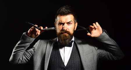 Macho in formal suit cuts and shaves beardの写真素材