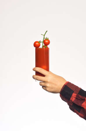 Mans wrist shows red cherry tomatoes and their product.の写真素材