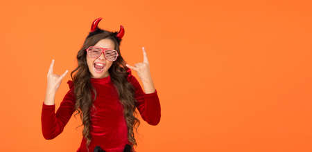time to have fun. carnival costume party. trick or treat. celebrate the holidays. childhood. copy space. happy halloween devil girl. teenage child in imp horns. cheerful kid wear funny party glassesの写真素材