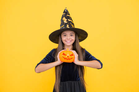 happy witch child with pumpkin jack o lantern wear costume of wizard on halloween party, halloween traditionの写真素材