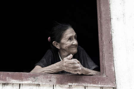 Smiling old woman in windowのeditorial素材