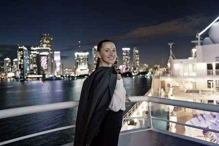 Business woman smile on ship board at night in miami, usa. Sensual woman in suit jacket on city...