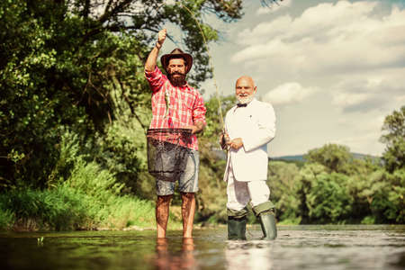 Lucky and skilled. Spinners and tackle. Nice catch. Bait and hook. Fellow fishermen. Good catch. Bearded men fishing. Family day. Hobby and recreation. Catching fish with friend. Friends catch fishの写真素材