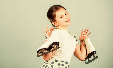Lets go skating. Happy child with skates hanging on neck. Little girl enjoy ice skating. Ice dance....
