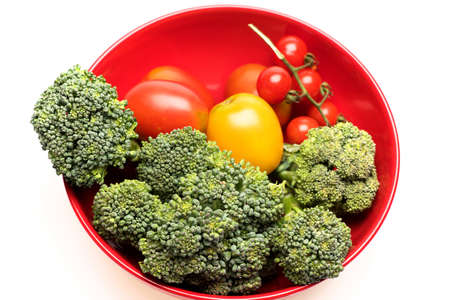 Composition of vegetables in bowl. Broccoli, red and yellow tomatoes