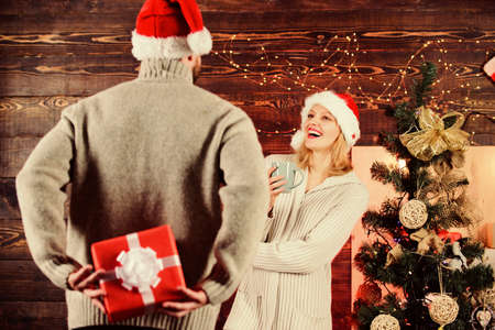 Eternal love. couple in love santa hat. Time for presents. happy new year. family holiday. cozy evening with your beloved. man share gift with woman. celebrate christmas together. winter seasonの写真素材