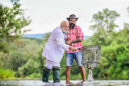 granddad and drandson fishing. fisher celebrate retirement. good production. Fishermen. successful...
