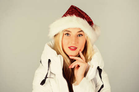 White jacket. Waiting frosty christmas days. Girl wear white jacket and santa hat. Jacket has extra...
