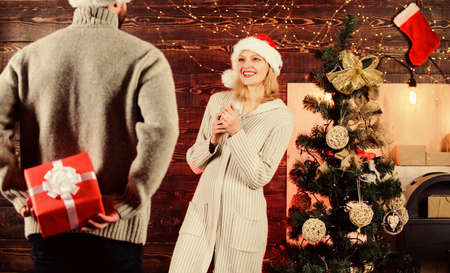 Man carry gift box behind back. Woman smiling face santa. Christmas surprise concept. Giving and...