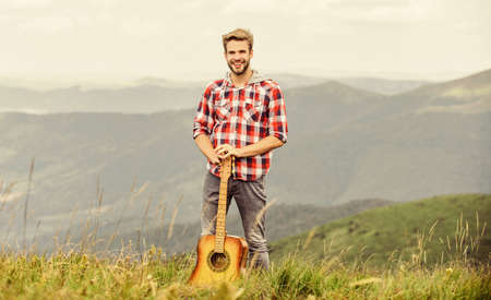 Hipster musician. Inspiring environment. Summer music festival outdoors. Playing music. Man musician...