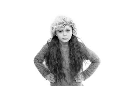 i feel anger. kid fashion. angry little kid isolated on white. ready for winter cold. small girl earflap hat and gloves. her favorite knitted sweater. active healthy childhood. autumn style lookの写真素材