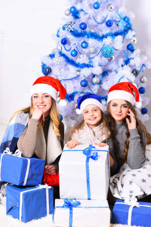 Girls with smiling faces with white and blue Christmas treeの写真素材